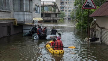 Los vecinos navegan en botes en una calle inundada durante la evacuación