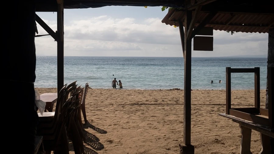 Imagen de archivo de turistas caminando por una playa de Bali, Indonesia