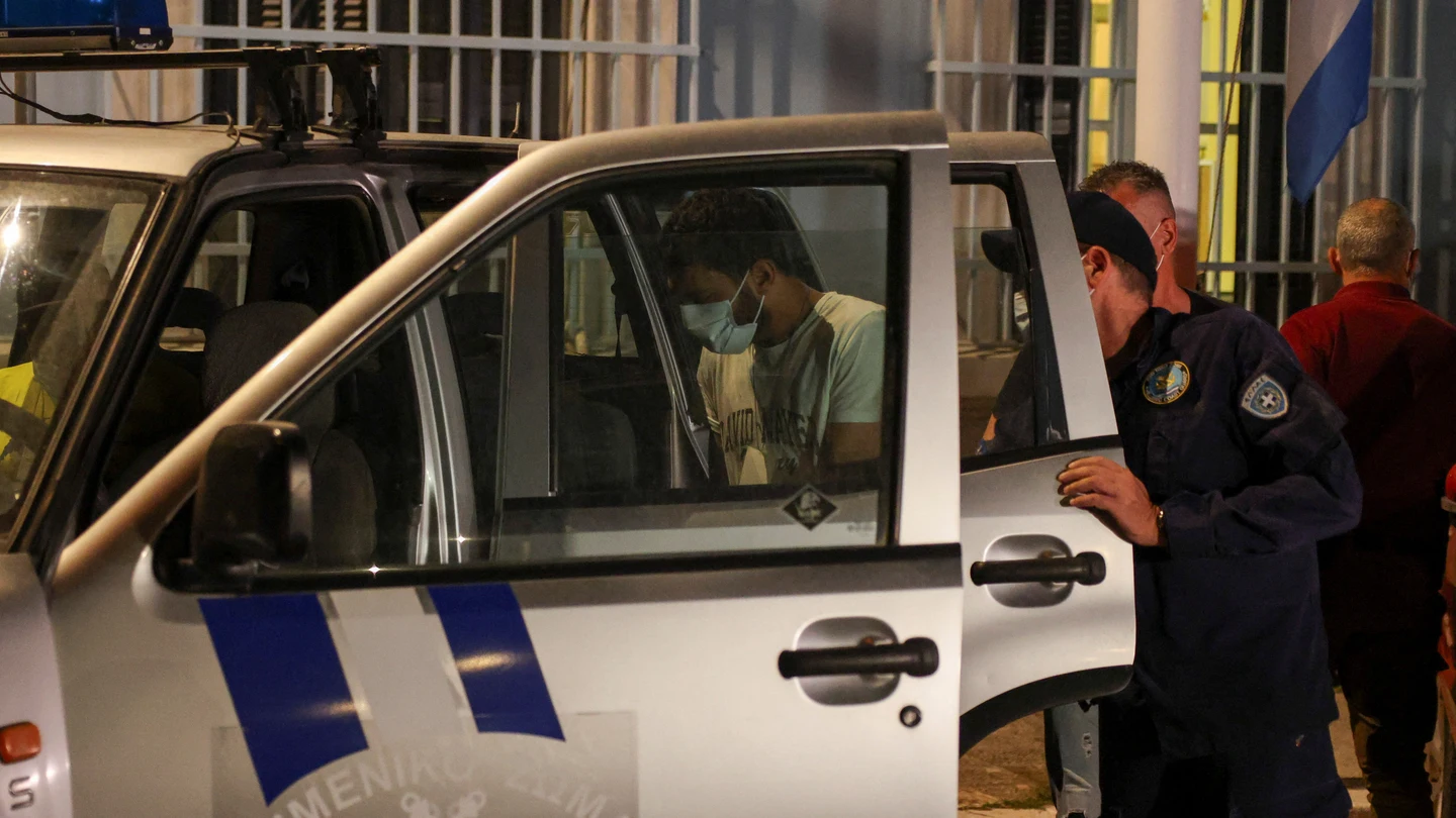 Oficial de policía portuaria escolta a un hombre egipcio, parte de un grupo de nueve egipcios que fueron arrestados por el naufragio. Oficial de policía portuaria escolta a un hombre egipcio, parte de un grupo de nueve egipcios que fueron arrestados por el naufragio.