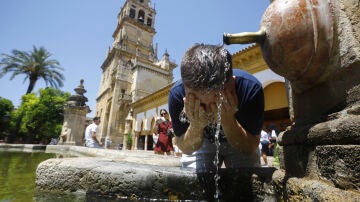 Un turista se refresca en una de las fuentes del patio de los naranjos de la Mezquita