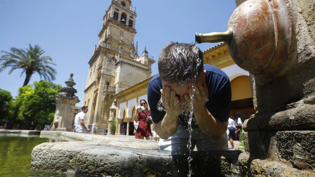 Un turista se refresca en una de las fuentes del patio de los naranjos de la Mezquita