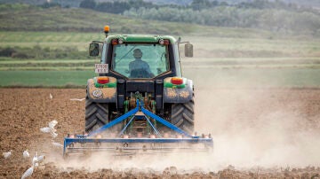 Imagen de archivo de un agricultor labrando con tractor la tierra