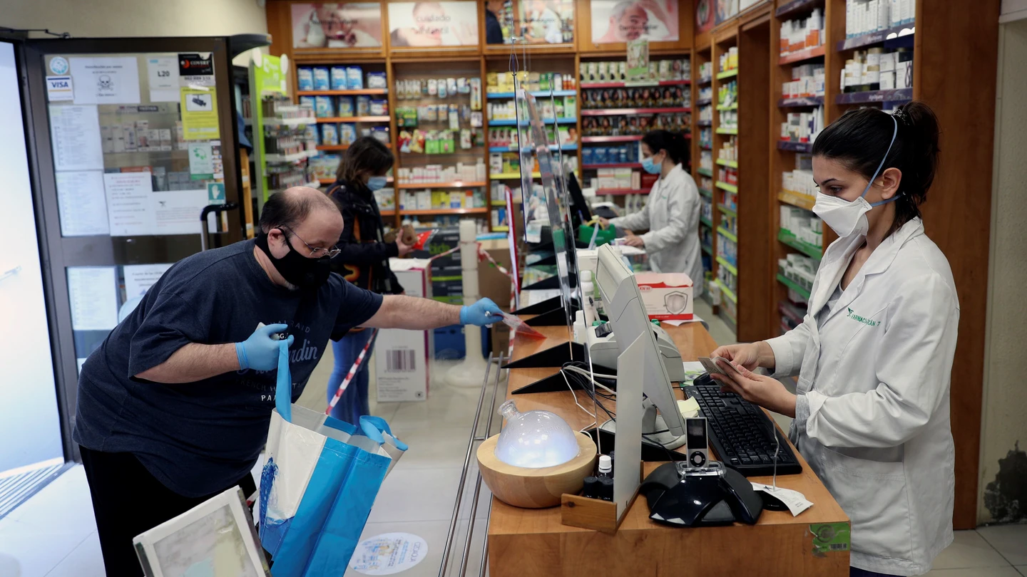 Dos personas son atendidas en una farmacia de Madrid. Dos personas son atendidas en una farmacia de Madrid.