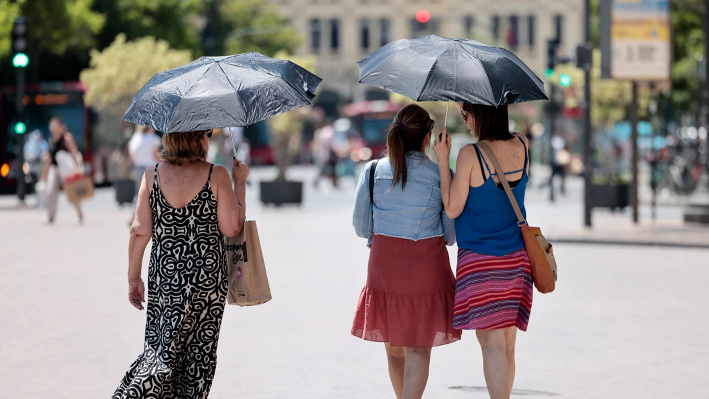 Tres mujeres se protegen del calor con unos paraguas Tres mujeres se protegen del calor con unos paraguas/ EFE/Ana Escobar