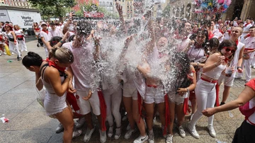Varias personas celebran el inicio de los sanfermines en la Plaza del Castillo de Pamplona tras el chupinazo que ha marcado el comienzo de las fiestas, este jueves. 