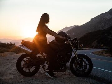 Mujer En Motocicleta En La Carretera Durante La Puesta De Sol