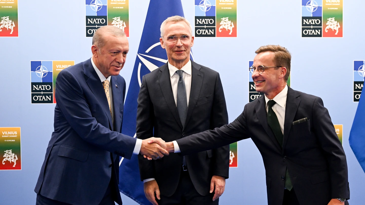 El presidente turco, Recep Tayyip Erdoğan, estrecha la mano al primer ministro sueco, Ulf Kristersson, en presencia del secretario general de la OTAN, Jens Stoltenberg. El presidente turco, Recep Tayyip Erdoğan, estrecha la mano al primer ministro sueco, Ulf Kristersson, en presencia del secretario general de la OTAN, Jens Stoltenberg.