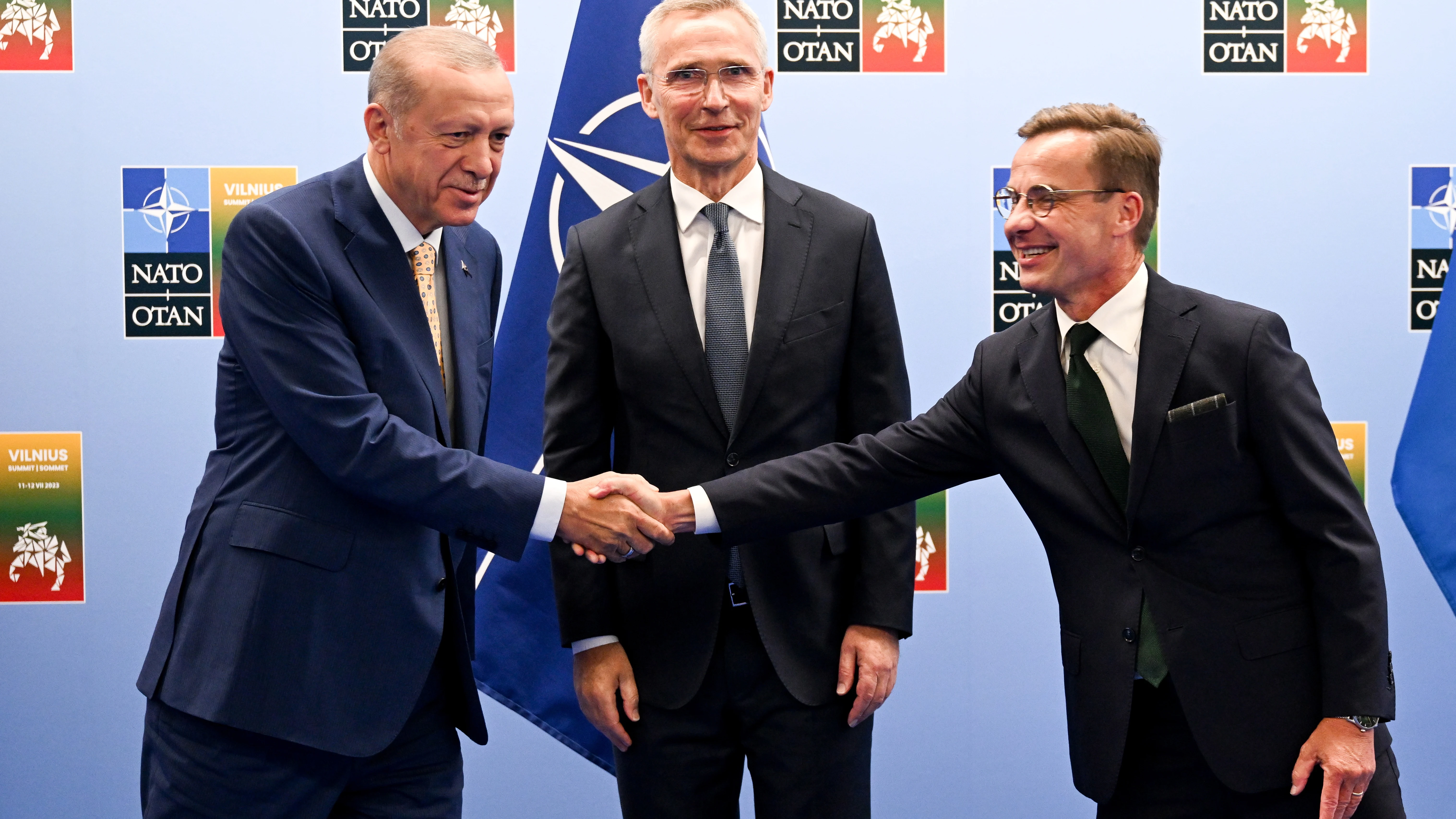 El presidente turco, Recep Tayyip Erdoğan, estrecha la mano al primer ministro sueco, Ulf Kristersson, en presencia del secretario general de la OTAN, Jens Stoltenberg.