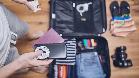 Joven haciendo la maleta para su viaje Joven haciendo la maleta para su viaje