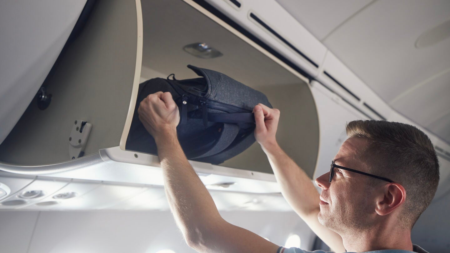 Hombre viajando con una mochila en el avi&oacute;n