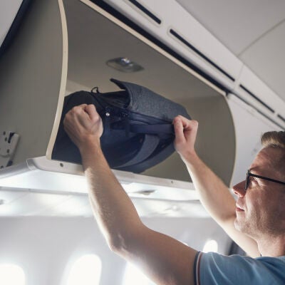 Hombre viajando con una mochila en el avi&oacute;n