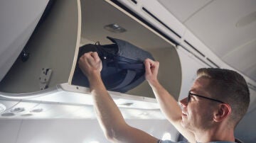 Hombre viajando con una mochila en el avión