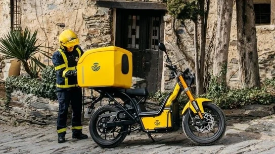 Imagen de archivo de un trabajador de Correos con una moto eléctrica. Imagen de archivo de un trabajador de Correos con una moto eléctrica.