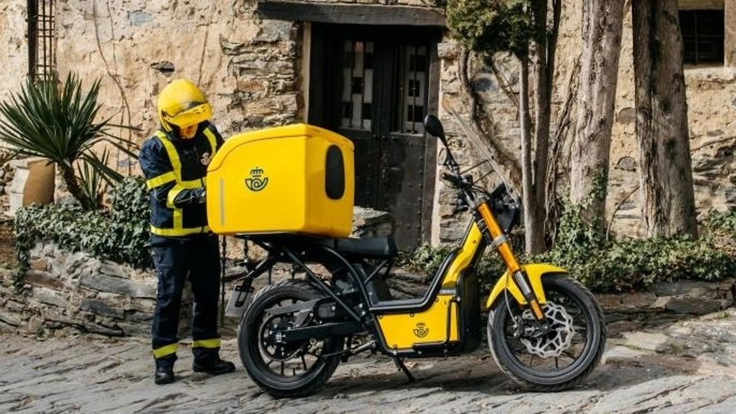 Imagen de archivo de un trabajador de Correos con una moto eléctrica. Imagen de archivo de un trabajador de Correos con una moto eléctrica.
