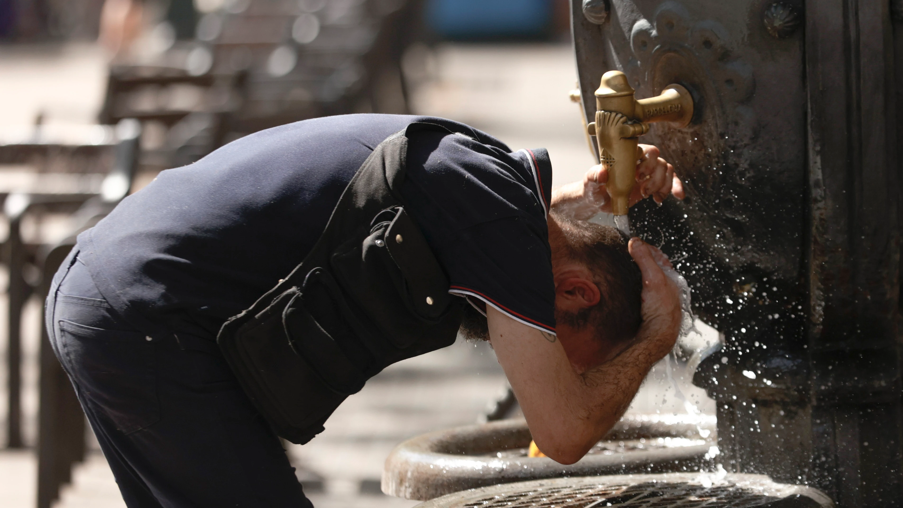 Un hombre se refresca en una fuente en el centro de Barcelona, este martes, cuando las temperaturas ya están escalando con intensidad en Cataluña.