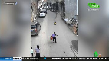 Un hombre salva a un niño que se precipita calle abajo en su moto de juguete