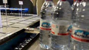 Papeletas, sobres, mesas y agua, dispuestos en un colegio electoral en Hinojos (Huelva), durante los preparativos de las elecciones generales. 