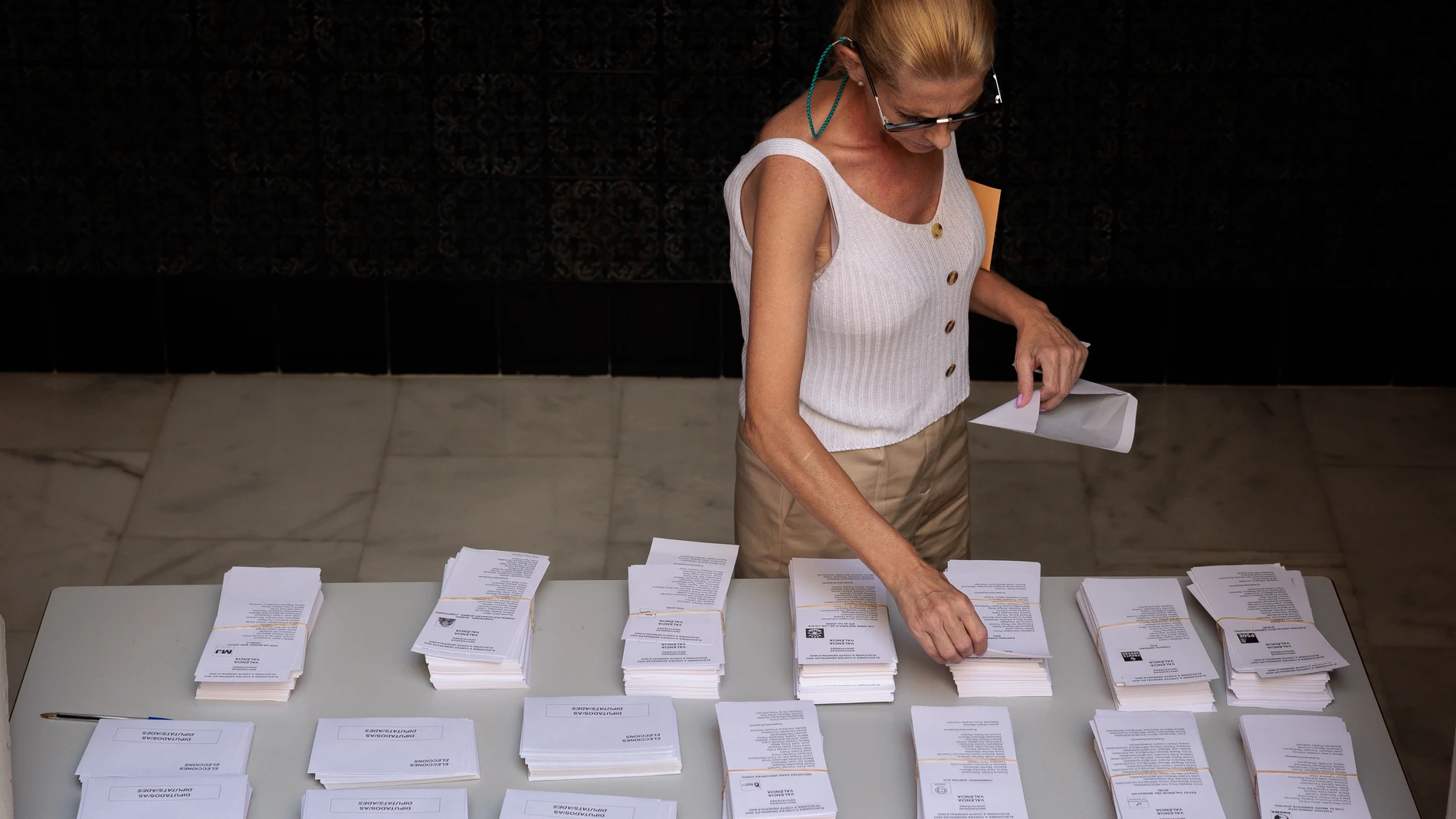Una mujer escoge una papeleta en un colegio electoral durante las elecciones generales de 2023