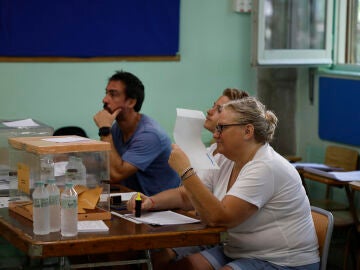 Una mujer, miembro de una mesa electoral, se abanica con un papel en la Escuela Merc&egrave; Rodoreda en Badalona