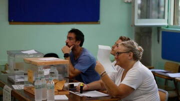 Una mujer, miembro de una mesa electoral, se abanica con un papel en la Escuela Mercè Rodoreda en Badalona