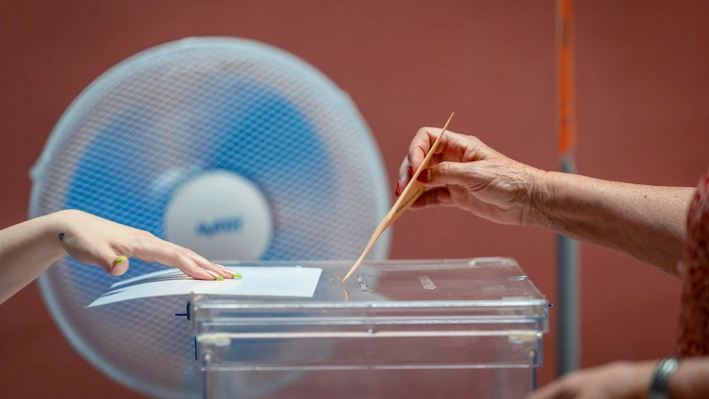 Una persona depositando su voto en una urna