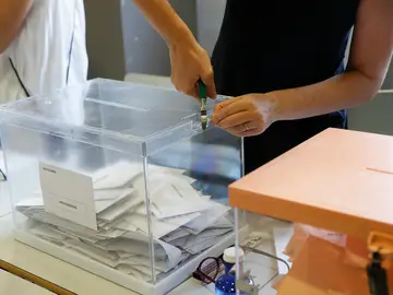 Imagen de archivo de la presidenta de una mesa electoral abriendo una urna el 23J