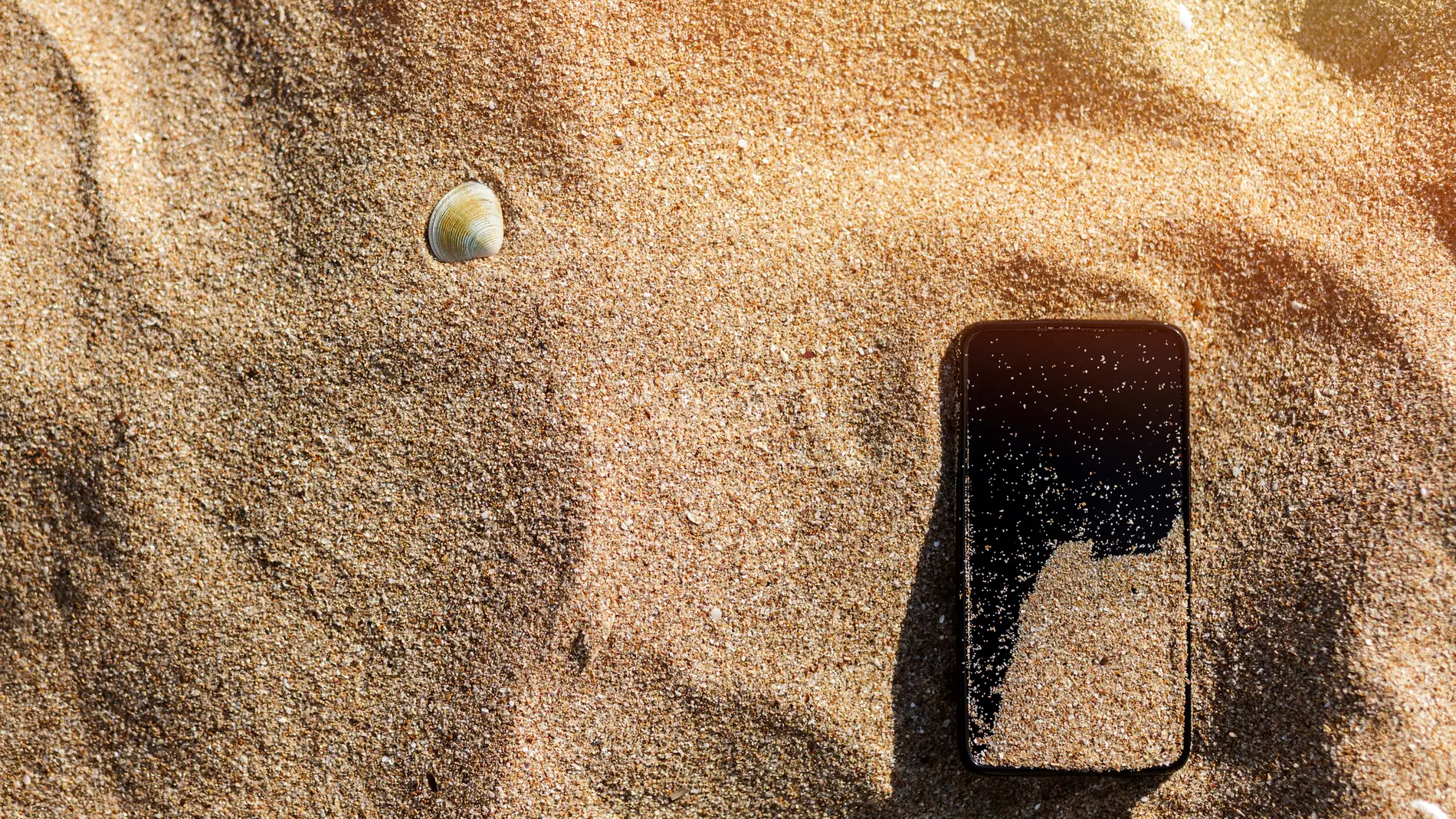 Un móvil en la arena de la playa
