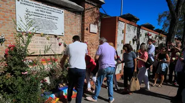 Familiares y amigos del corresponsal de guerra y escritor, Ramón Lobo, ponen flores en la placa de las 13 rosas en el cementerio de la Almudena.