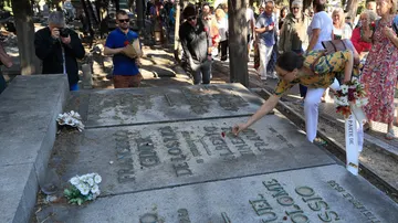 Familiares y amigos del corresponsal de guerra y escritor, Ramón Lobo, ponen flores en la tumba de Francisco Ginés de los Ríos, de la Institución Libre de Enseñanza, en el cementerio de la Almudena