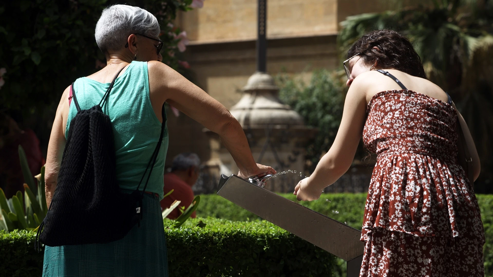 Dos mujeres se refrescan en una fuente