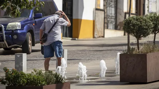 Un hombre se refresca en una fuente en las calles de Mérida.  Un hombre se refresca en una fuente en las calles de Mérida.