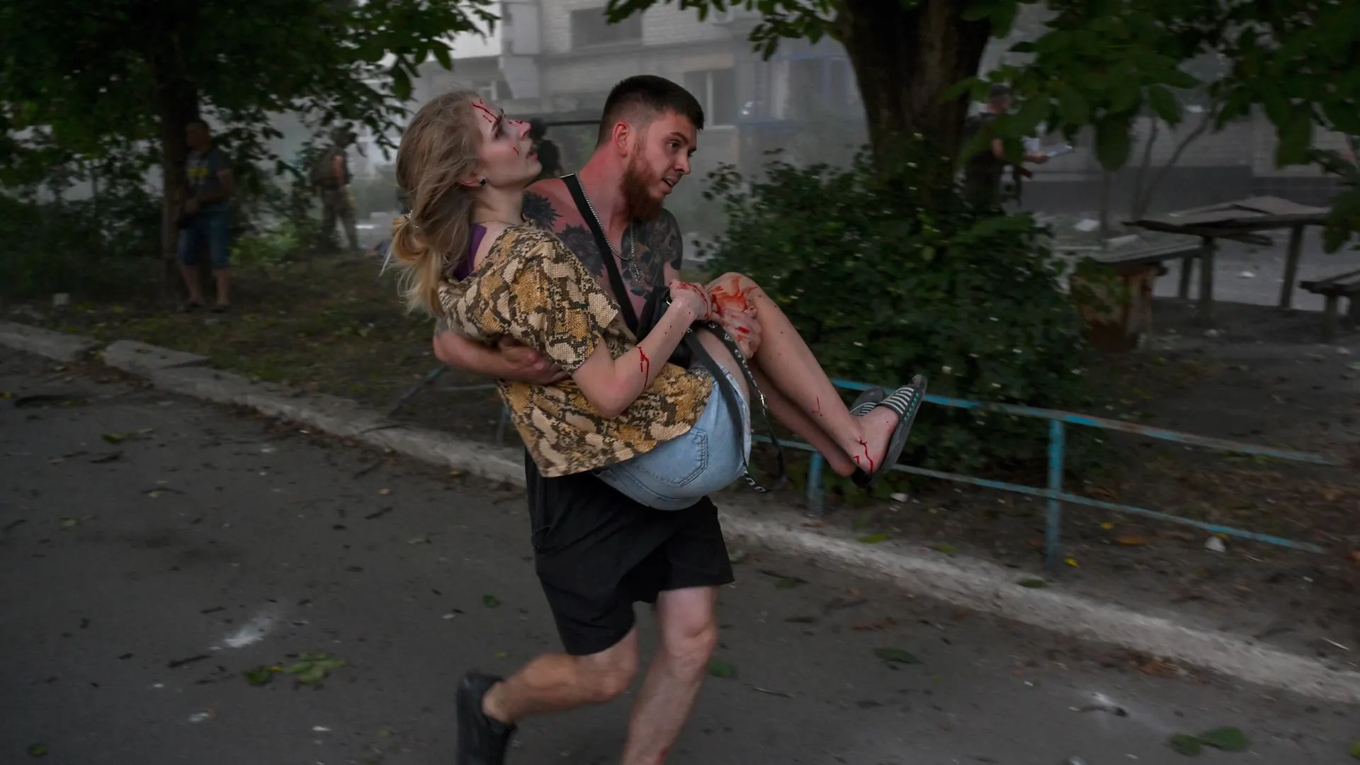 Un hombre carga a una mujer ucraniana herida tras la explosión de un segundo cohete en la ciudad de Pokrovsk.