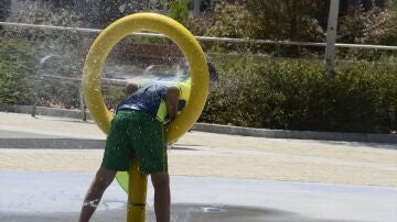 Un niño echándose agua en un parque de Galicia.