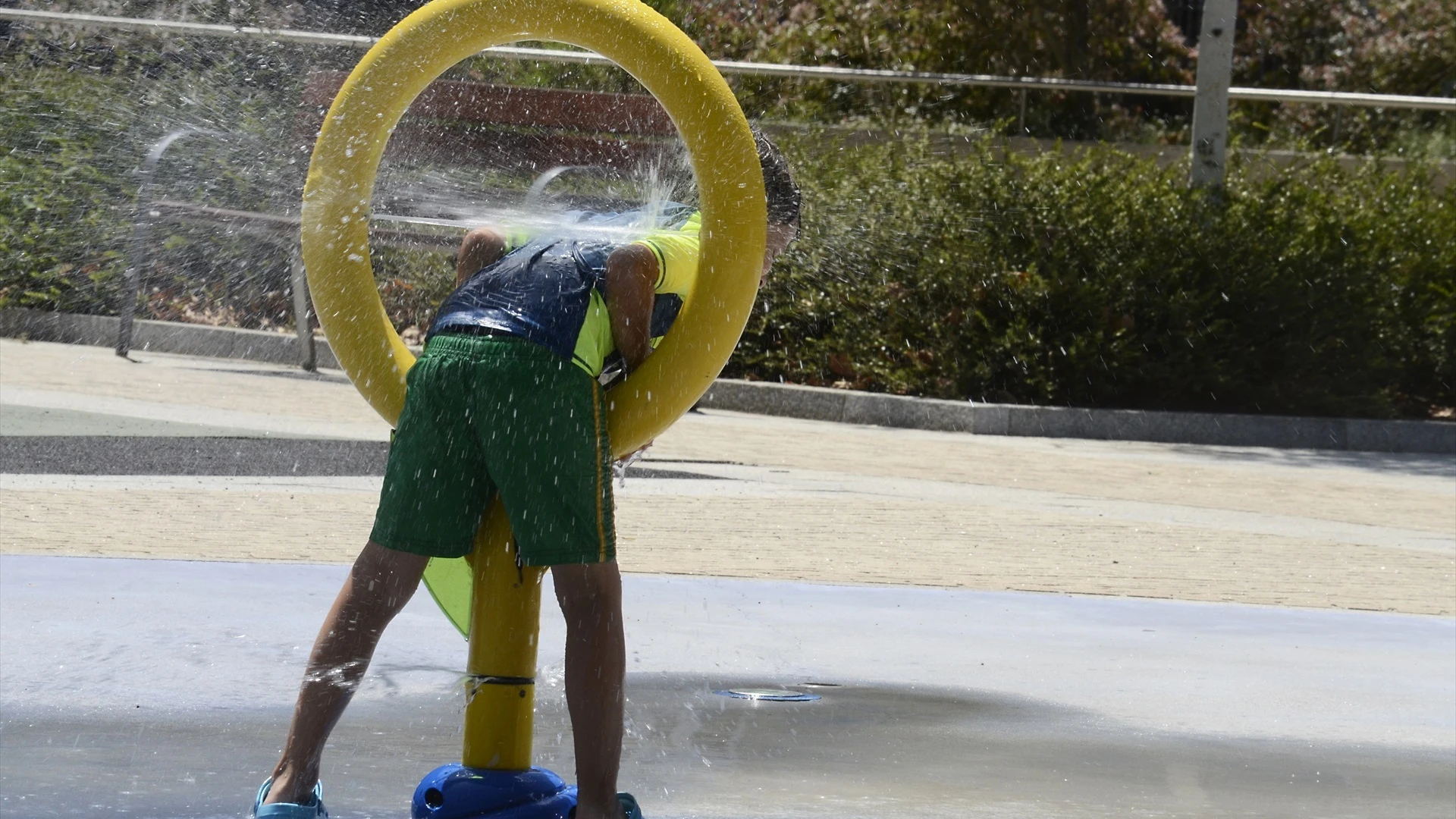 Un niño echándose agua en un parque de Galicia.