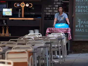 Una camarera coloca las mesas en un bar de Toledo, en una imagen de archivo Una camarera coloca las mesas en un bar de Toledo, en una imagen de archivo