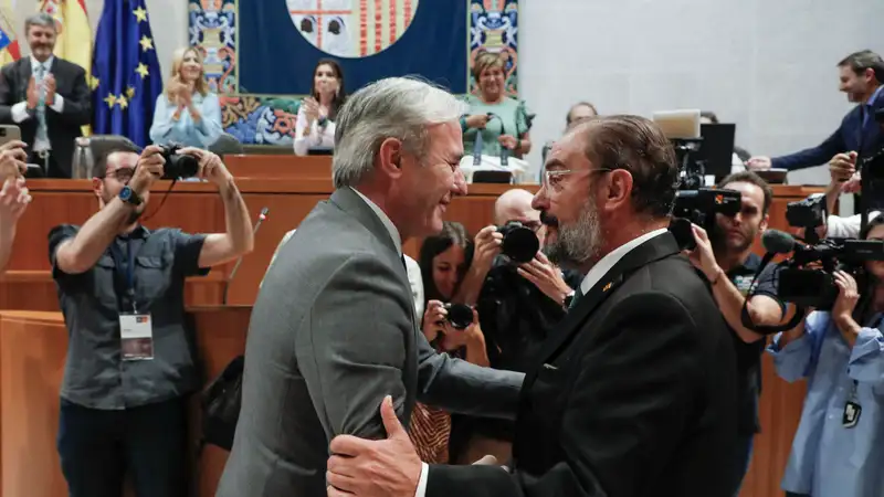 El nuevo presidente de Aragón, Jorge Azcón, saluda a su antecesor, el socialista Javier Lambán, tras ser investido