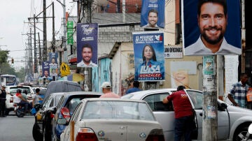 Fotografía de varias pancartas de los candidatos a la presidencia de Ecuador en una calle de Guayaquil.