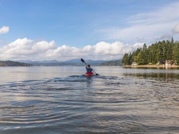 Joven haciendo Kayak en un lago