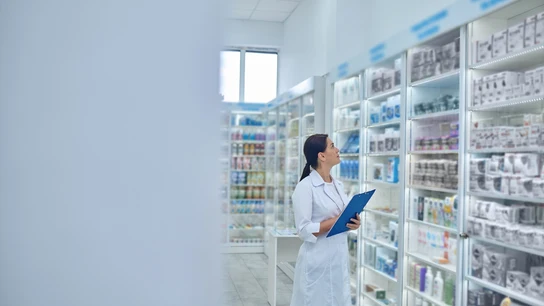 Farmacéutica revisando medicamentos en una farmacia. Farmacéutica revisando medicamentos en una farmacia.