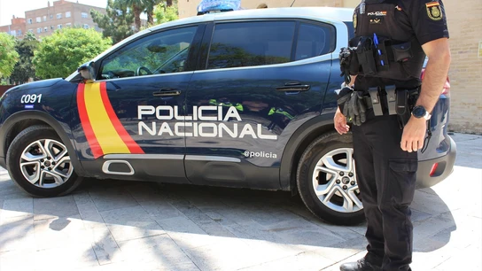 Imagen de archivo de un agente junto a un coche de la Policía Nacional. Imagen de archivo de un agente junto a un coche de la Policía Nacional.