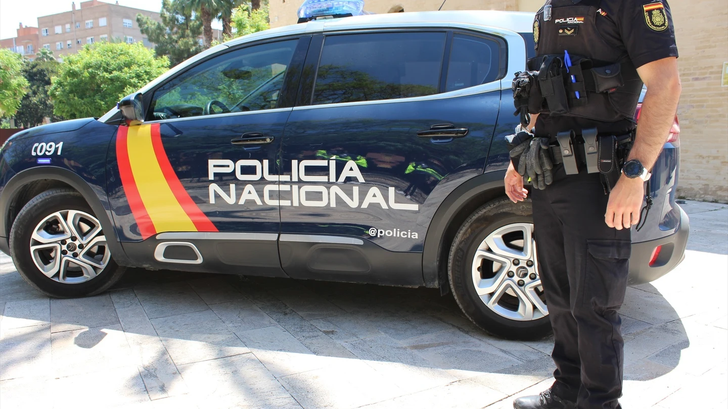 Imagen de archivo de un agente junto a un coche de la Policía Nacional. Imagen de archivo de un agente junto a un coche de la Policía Nacional.