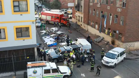 Bomberos trabajan en las labores de búsqueda y rescate tras el incendio del edificio.