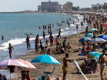 Numerosas personas disfrutan de un día de baño en la Playa de la Misericordia