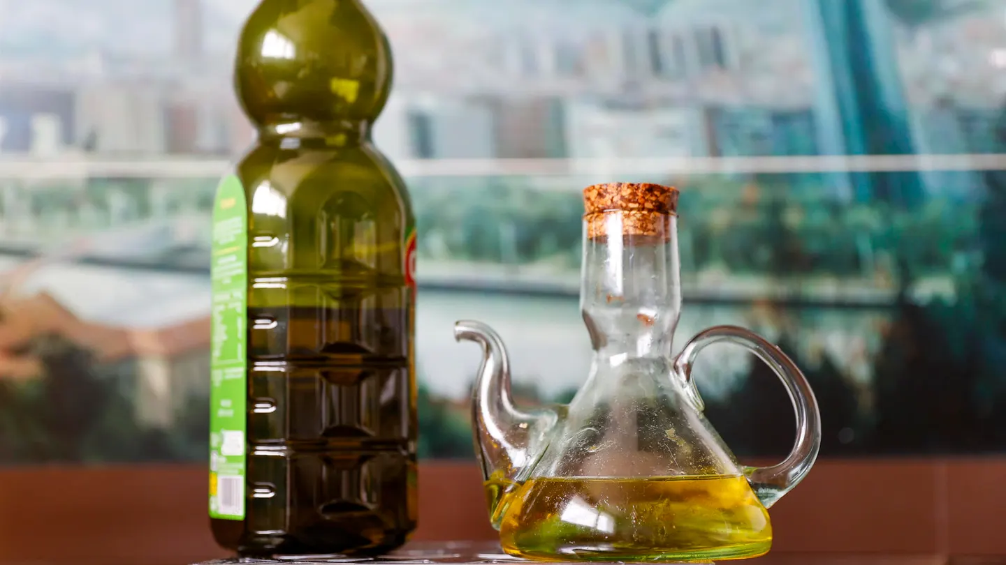 Una botella y una aceitera con aceite de oliva virgen Una botella y una aceitera con aceite de oliva virgen