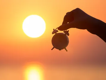 Persona sujetando un reloj Persona sujetando un reloj