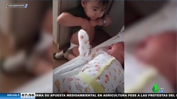 El inocente gesto de un niño pequeño que intenta darle el pecho a su hermano recién nacido para que deje de llorar