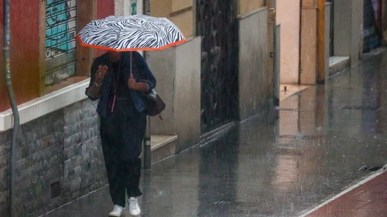 Una mujer camina bajo la lluvia en Valencia. Una mujer camina bajo la lluvia en Valencia.