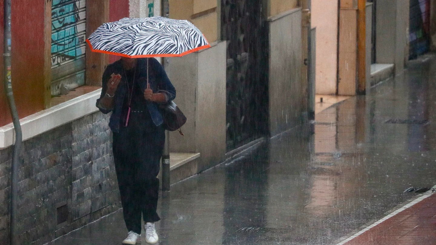 Una mujer camina bajo la lluvia en Valencia. Una mujer camina bajo la lluvia en Valencia.