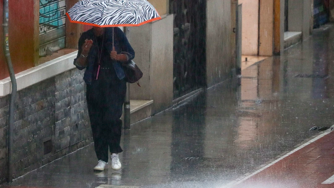 Una mujer camina bajo la lluvia en Valencia. 