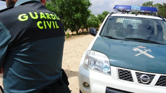 Imagen de archivo de un agente junto a un vehículo de la Guardia Civil Imagen de archivo de un agente junto a un vehículo de la Guardia Civil